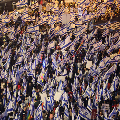 Demonstrators wave flags during a rally to protest the Israeli government's judicial overhaul plans, in Tel Aviv, on April 22, 2023. (JACK GUEZ / AFP)