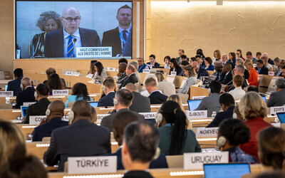 UN High Commissioner for Human Rights Volker Turk (C) is seen on a giant screen as he delivers a speech at the opening of the 53rd UN Human Rights Council in Geneva, on June 19, 2023. (Photo by Fabrice COFFRINI / AFP)