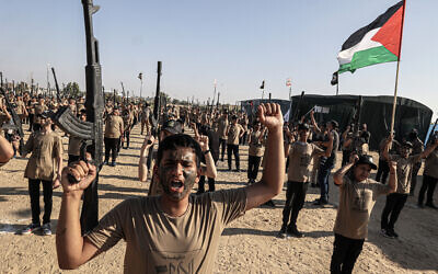 Palestinian youths brandishing fake rifles parade during a military-style summer camp organized annually by the Palestinian Islamic Jihad terror group during the school holiday, in Khan Yunis in the southern Gaza Strip, on June 22, 2023. (SAID KHATIB / AFP)