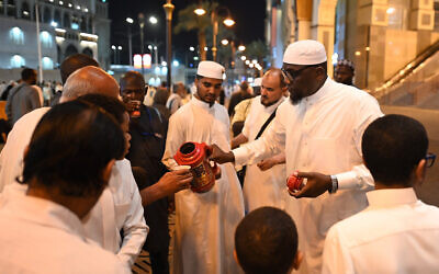 A Saudi family distributes free tea to pilgrims, as Muslims from around the world arrive to attend the annual Hajj pilgrimage, in the holy Saudi city of Mecca on June 23, 2023. (Sajjad HUSSAIN / AFP)