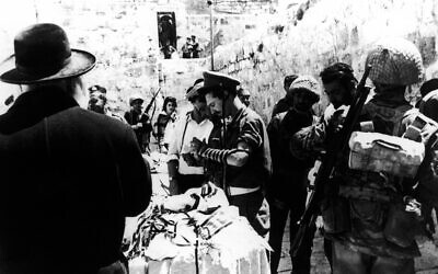 In this June 8, 1967 file photo a man lends prayer shawls and phylacteries to Israeli soldiers praying at the Western Wall in the Old City of Jerusalem, one day after its capture from the Jordanians during the Six-Day War. (AP Photo, File)