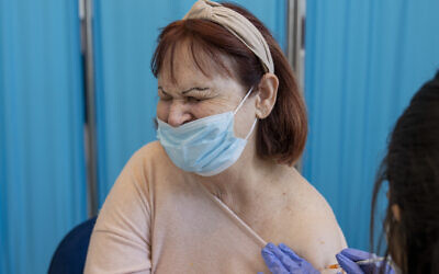 An Israeli woman receives her fourth dose of the coronavirus vaccine in a private nursing home in Petah Tikva, Israel, Tuesday, Jan. 4, 2022.  (AP Photo/Ariel Schalit)