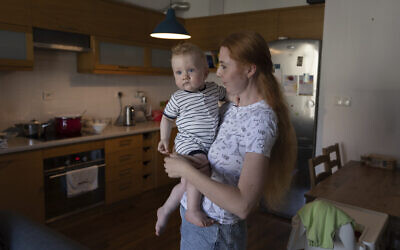 Taisiia Mokrozub, a Ukrainian refugee from Zaporizhzhia, holds her son Hordii during an interview with The Associated Press in a flat in Pruszkow, Poland, August 17, 2022. (AP Photo/Michal Dyjuk)