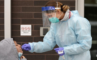 File: A nurse administers a COVID-19 test outside the Salt Lake County Health Department, Tuesday, December 20, 2022, in Salt Lake City. (AP Photo/Rick Bowmer, File)