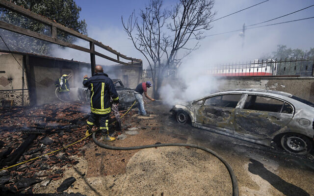 Palestinian firefighters try to extinguish a fire set by settlers in the West Bank town of Turmus Ayya, June 21, 2023. (AP Photo/Majdi Mohammed)