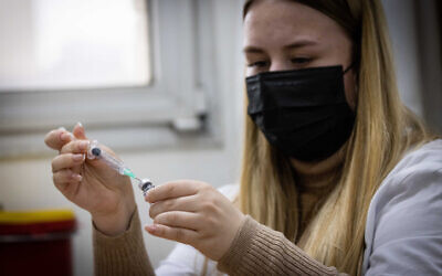 File - a health worker prepares a vaccine dose at a vaccination center in Jerusalem on January 4, 2022. (Yonatan Sindel/Flash90)