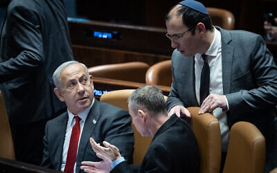 Prime Minister Benjamin Netanyahu (left) with the architects of the proposed judicial overhaul, Justice Minister Yariv Levin and MK Simcha Rothman (standing) in the Knesset on February 15, 2023. (Yonatan Sindel/Flash90)