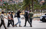 Israeli soldiers and settlers at the entrance to the West Bank town of Turmus Aya, June 21, 2023. (Yonatan Sindel/FLASH90)