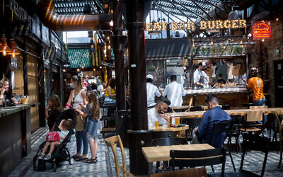 Customers at restaurants at the Sarona market in Tel Aviv on April 21, 2021. (Miriam Alster/Flash90)