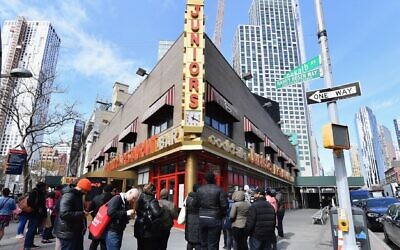 People stand in line outside Junior's restaurant to pick up food to go on March 16, 2020 in the Brooklyn Borough of New York City (ANGELA WEISS/AFP via Getty Images, JTA)