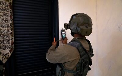 An Israeli soldier takes measurements at the home of Khaled Kharousha, accused of helping his father, a Hamas terrorist, in carrying out a deadly attack in Huwara, in the West Bank city of Nablus early May 13, 2023. (Israel Defense Forces)